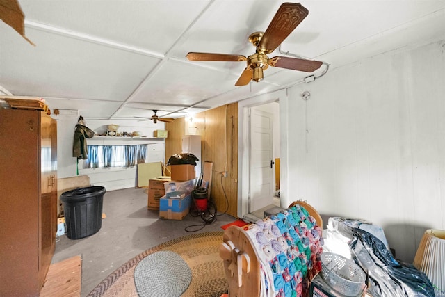 living room featuring ceiling fan and concrete flooring