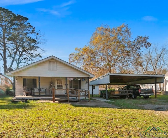 view of front of home with a carport, covered porch, and a front yard