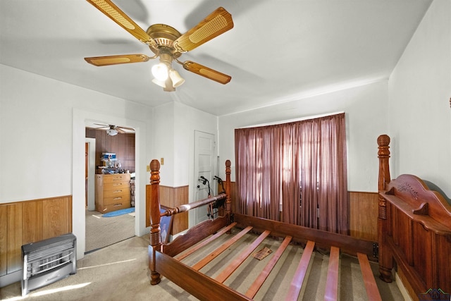 bedroom featuring ceiling fan, wooden walls, and carpet floors