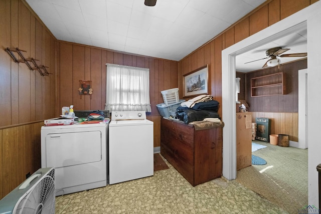 clothes washing area with separate washer and dryer, wooden walls, and ceiling fan