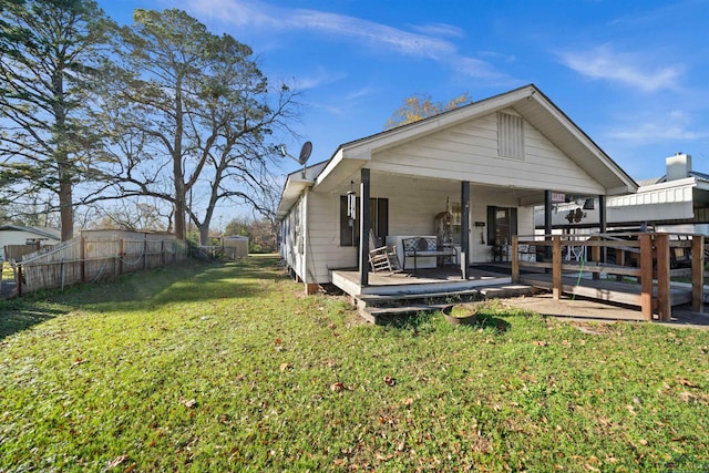 rear view of house featuring a deck and a lawn