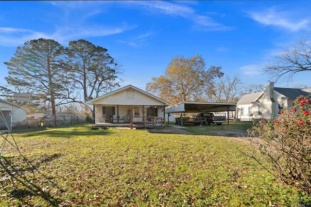 back of property with a yard, a carport, and a porch