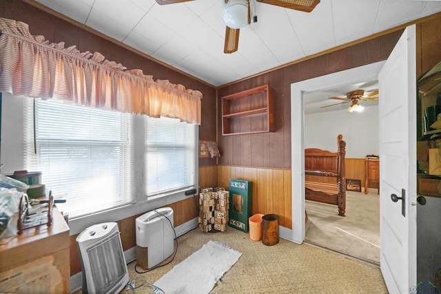 interior space featuring ceiling fan, carpet floors, and wooden walls