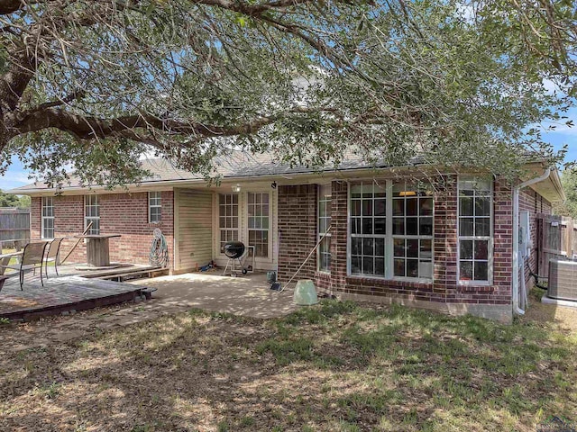 back of property with fence, a patio area, brick siding, and cooling unit