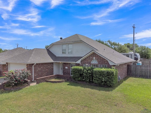 traditional home featuring brick siding, a front lawn, a garage, and fence