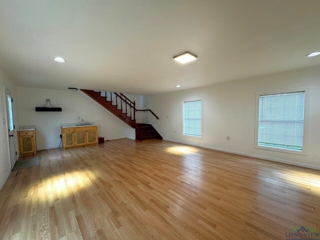 308 E 14th St, Mount Pleasant, TX 75455 - unfurnished living room with baseboards, stairs, light wood-style flooring, and recessed lighting