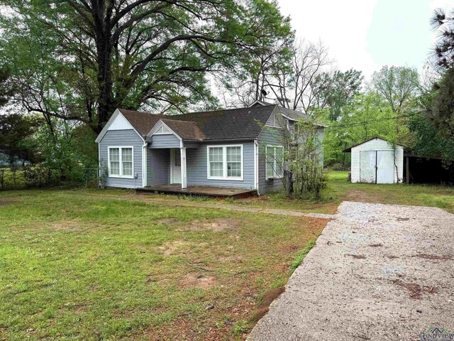308 E 14th St, Mount Pleasant, TX 75455 - bungalow-style house with a front lawn, an outdoor structure, and a storage shed