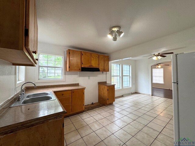 308 E 14th St, Mount Pleasant, TX 75455 - kitchen with brown cabinets, a wealth of natural light, a sink, and freestanding refrigerator