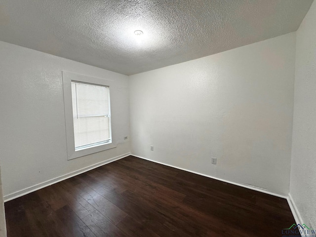 308 E 14th St, Mount Pleasant, TX 75455 - spare room featuring dark wood finished floors, baseboards, a textured wall, and a textured ceiling