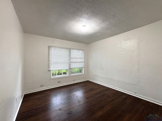 308 E 14th St, Mount Pleasant, TX 75455 - spare room with dark wood-style floors, a textured wall, baseboards, and a textured ceiling
