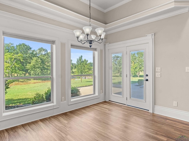 interior space with hardwood / wood-style floors, crown molding, a wealth of natural light, and an inviting chandelier