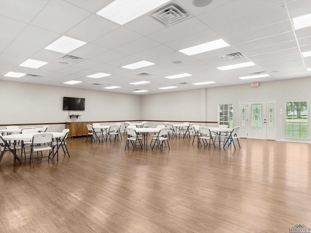 dining area with a drop ceiling and hardwood / wood-style flooring