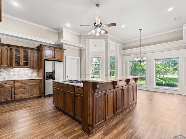 kitchen with decorative backsplash, a kitchen island, crown molding, and appliances with stainless steel finishes