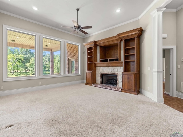 unfurnished living room featuring ceiling fan, light colored carpet, ornamental molding, and a fireplace