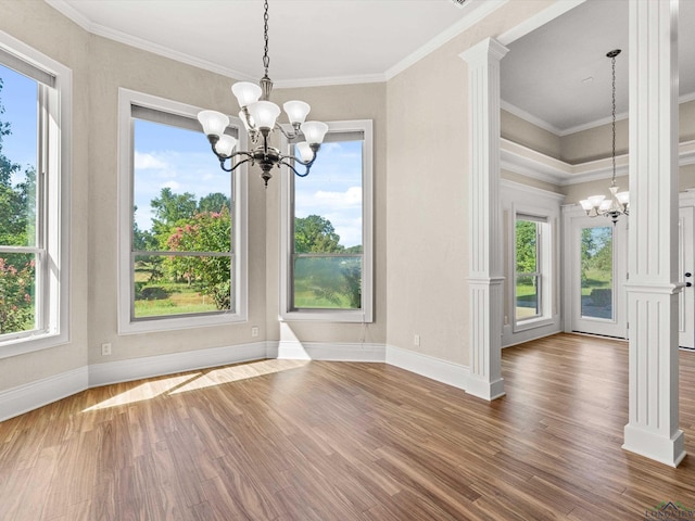 unfurnished dining area with crown molding, a healthy amount of sunlight, and an inviting chandelier