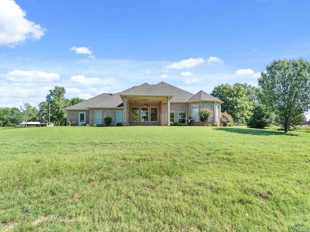 ranch-style home featuring ceiling fan and a front lawn