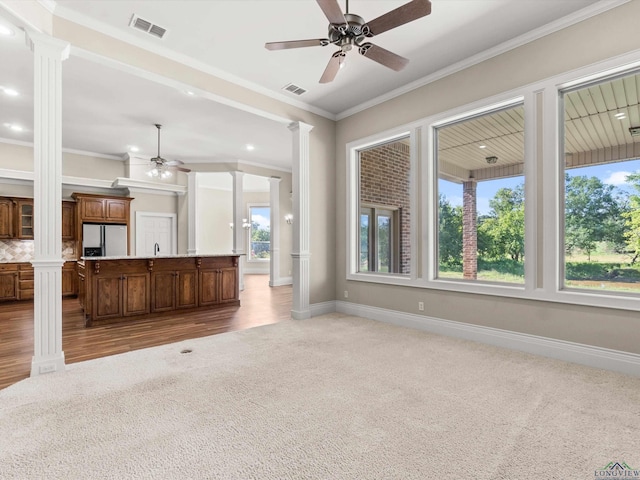 unfurnished living room with carpet flooring, ornate columns, and ornamental molding