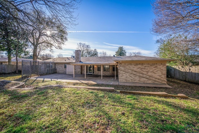 rear view of property with a yard and a patio