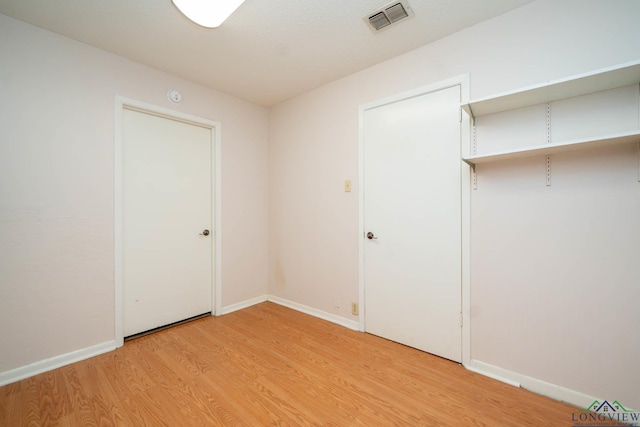 unfurnished bedroom featuring light hardwood / wood-style floors and a closet