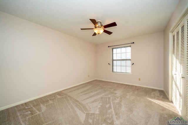 unfurnished bedroom featuring light carpet, a closet, and ceiling fan