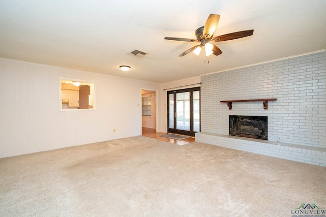 unfurnished living room with ceiling fan, a fireplace, light carpet, and french doors