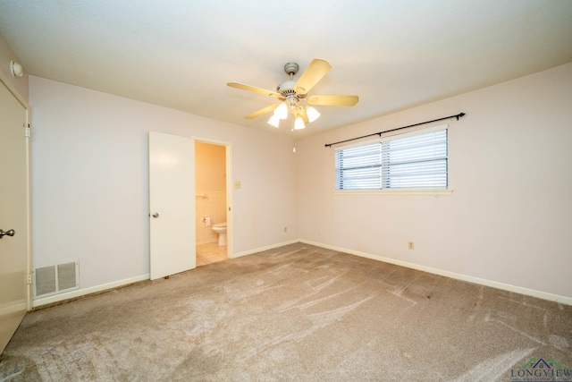 unfurnished bedroom with connected bathroom, ceiling fan, and carpet