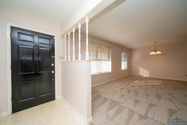 foyer entrance with light colored carpet and an inviting chandelier