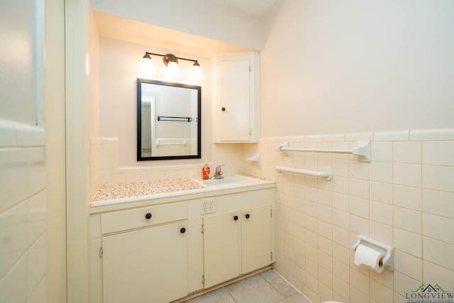 bathroom with tile patterned flooring, vanity, and tile walls