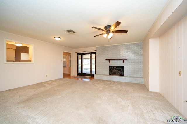 unfurnished living room featuring carpet flooring, ceiling fan, and a brick fireplace