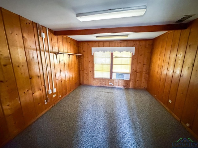 empty room featuring cooling unit, wood walls, and beamed ceiling