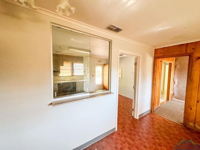 hallway featuring crown molding and wooden walls