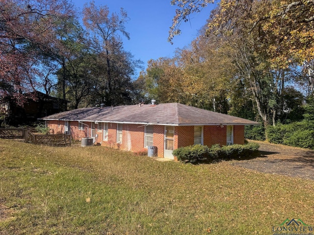 view of side of home with a yard and cooling unit