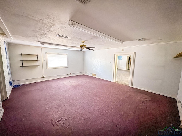 carpeted empty room featuring ceiling fan and a textured ceiling