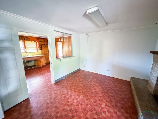 unfurnished living room featuring a fireplace, a notable chandelier, and ornamental molding