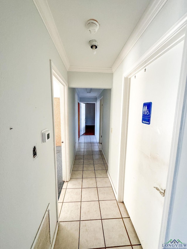 corridor with light tile patterned floors and ornamental molding