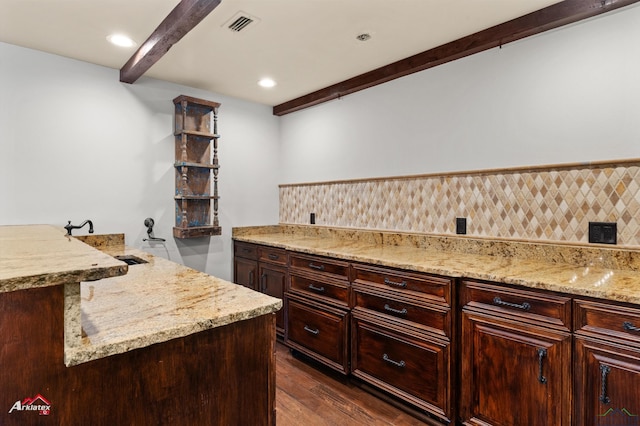 kitchen with beamed ceiling, dark hardwood / wood-style floors, light stone countertops, and backsplash