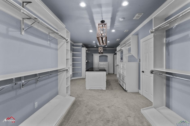 spacious closet featuring light carpet