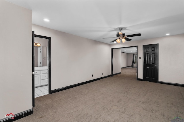 spare room with light colored carpet and ceiling fan