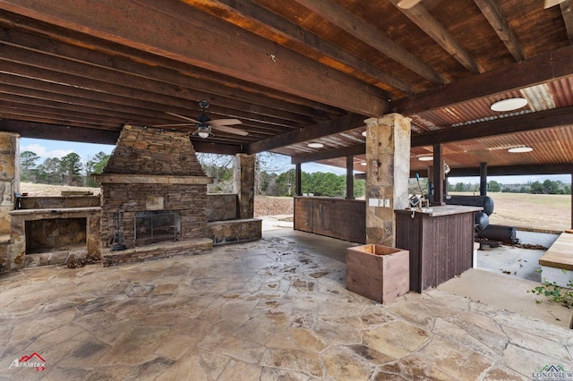 view of patio with an outdoor stone fireplace and ceiling fan