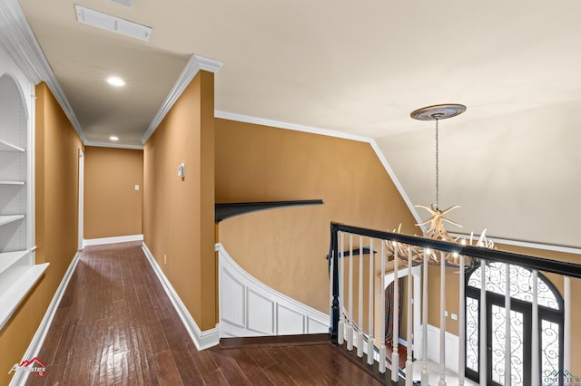 hallway with crown molding, hardwood / wood-style floors, and a notable chandelier