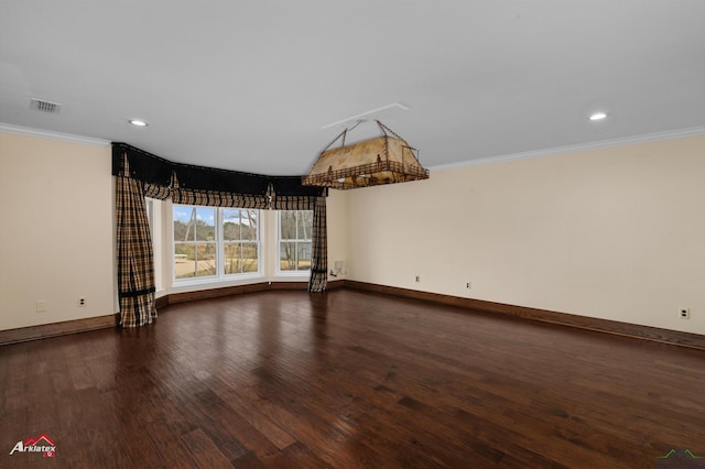 empty room featuring dark wood-type flooring and crown molding