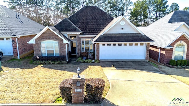 view of front of house with concrete driveway, brick siding, a front lawn, and an attached garage