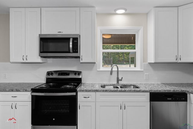 kitchen featuring white cabinets, appliances with stainless steel finishes, backsplash, and sink