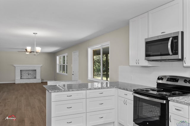 kitchen with kitchen peninsula, hardwood / wood-style floors, white cabinets, and stainless steel appliances