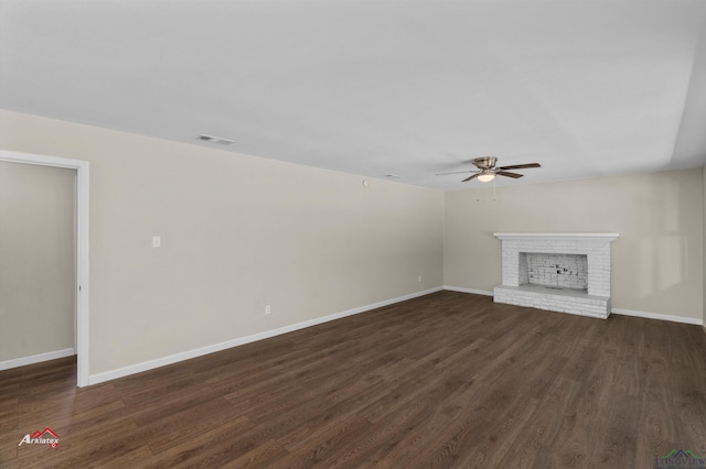 unfurnished living room with dark hardwood / wood-style floors, a brick fireplace, and ceiling fan