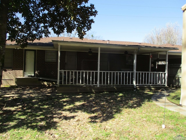 back of house featuring covered porch and brick siding