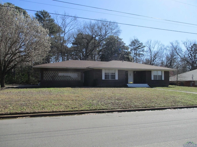 ranch-style house featuring brick siding and a front lawn