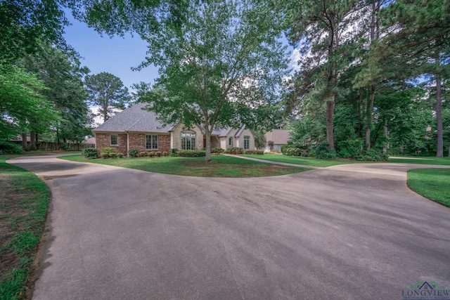 7 Summer Creek Way, Longview, TX 75604 - view of front of house featuring curved driveway, brick siding, and a shingled roof