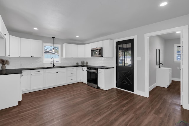 kitchen with white cabinets, decorative light fixtures, and stainless steel appliances