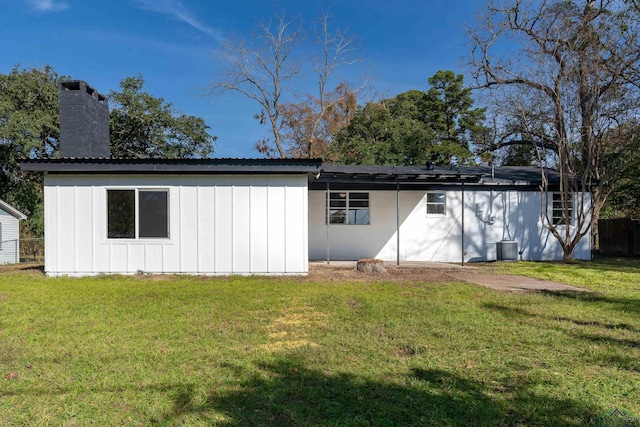 back of house with a lawn and cooling unit